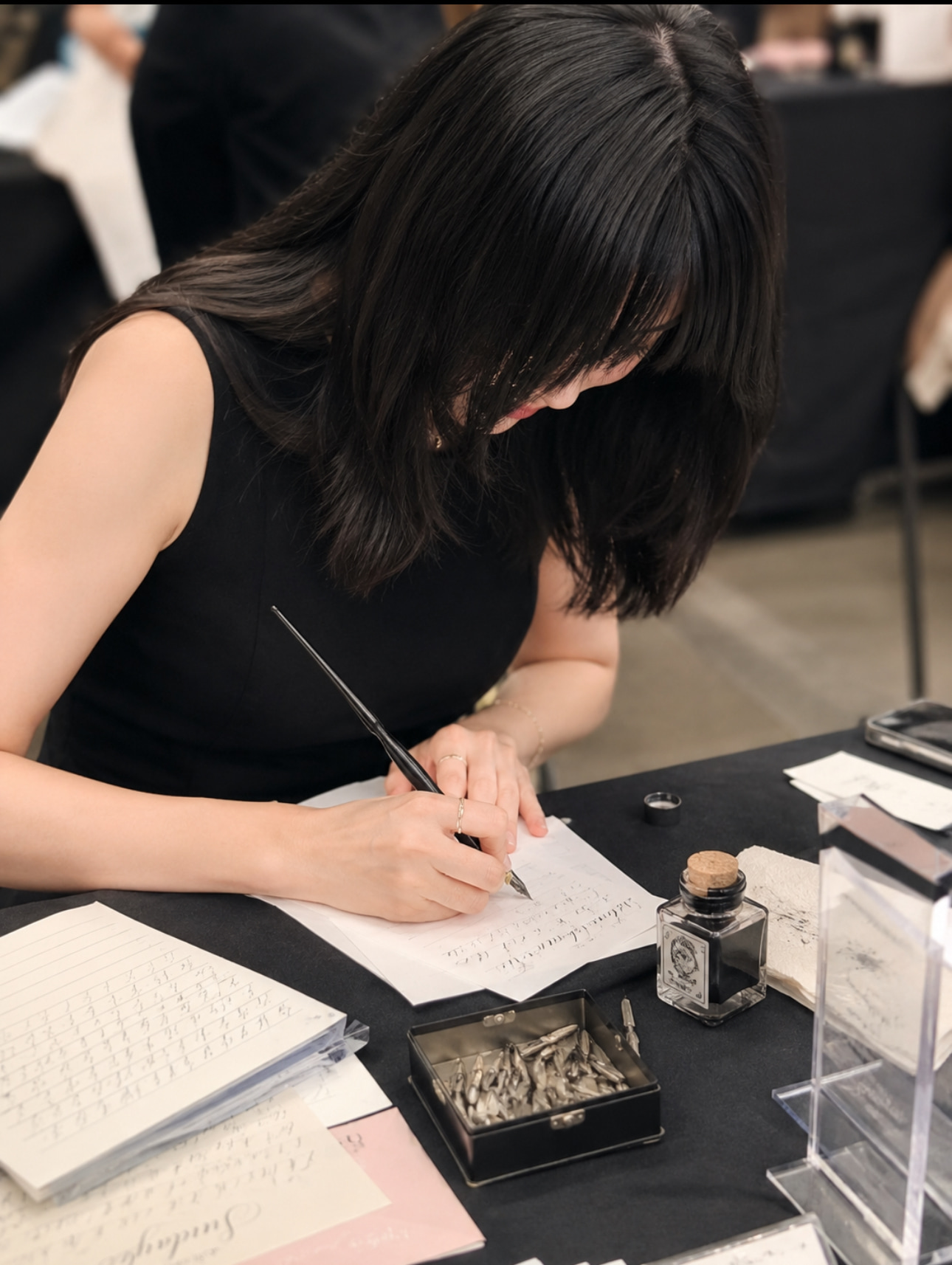 Raven Hsieh writing calligraphy with a dip pen